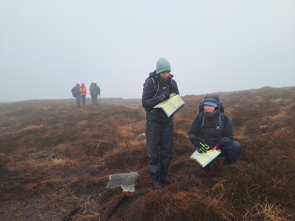 Contour Interpretation. Two hikers with maps in foggy landscape.