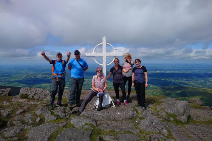 a group of people standing on a rocky hill