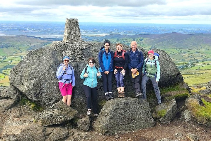 a group of people standing in a rocky area posing for the camera