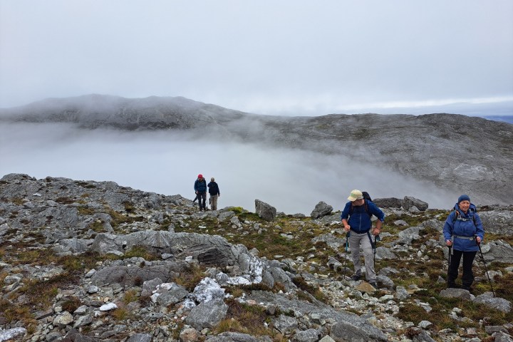 a group of people walking up a hill in the snow